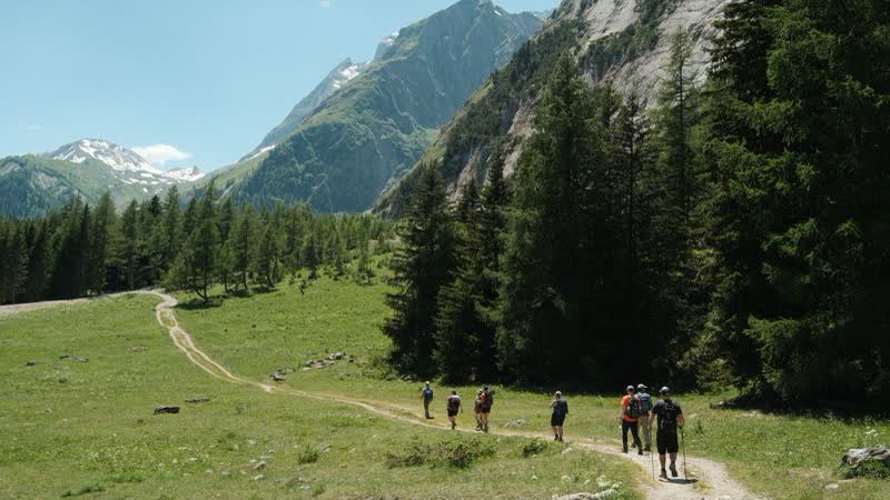 Wandergruppe auf einem Weg durch ein Alpental in der Schweiz